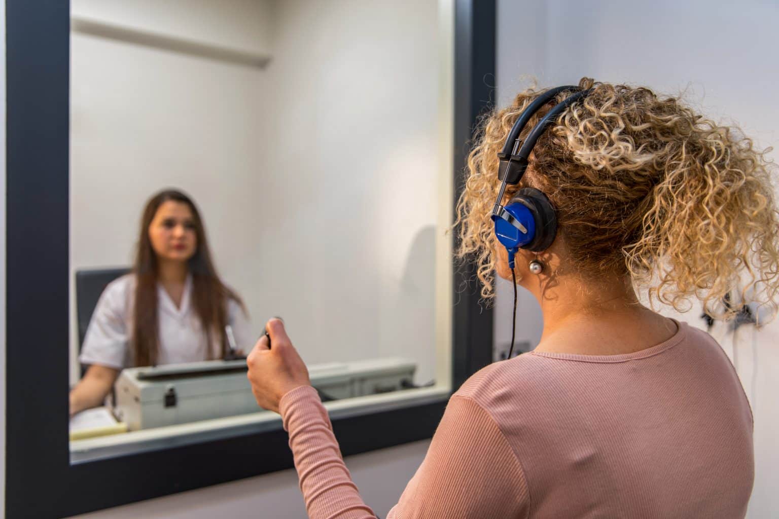 An audiologist performing a hearing test on a patient.