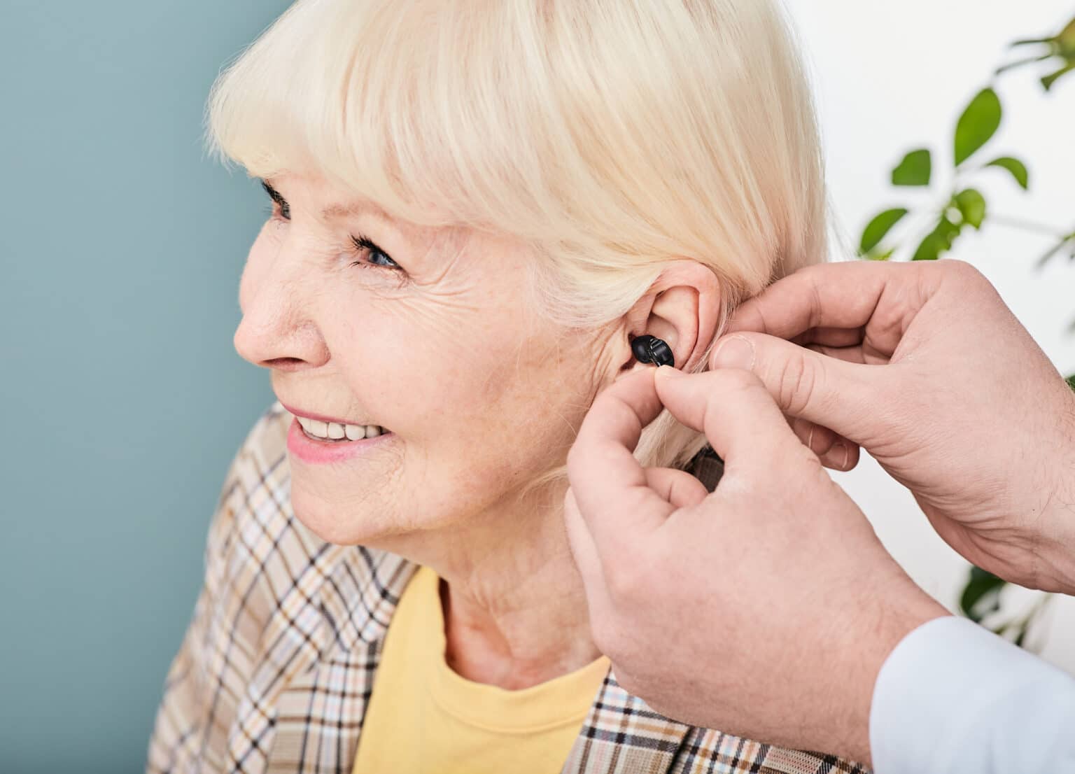 Smiling senior woman getting fitted for hearing aids.