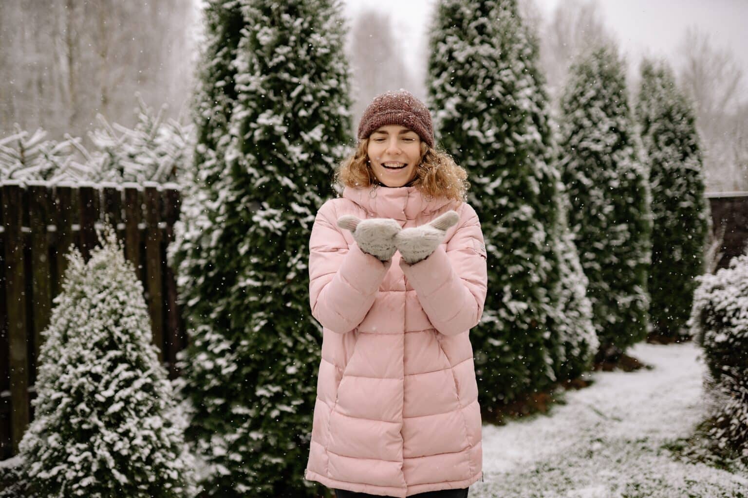 Young woman standing out in the snow.