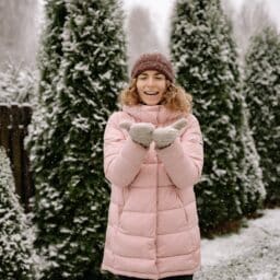 Young woman standing out in the snow.