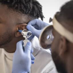Doctor looking inside a patient's ear for excess earwax