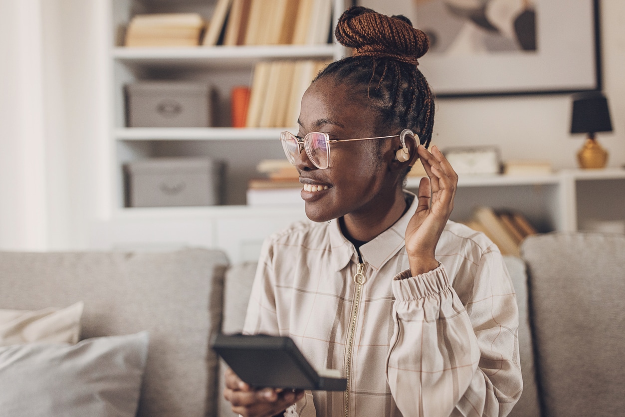 Young woman showing off her hearing aid.