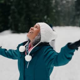 Senior woman enjoying the snowin the forest